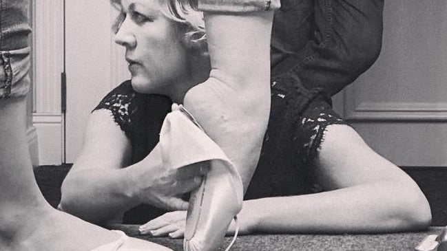 Keri Suffolk fitting a pointe shoe on a dancer's foot.