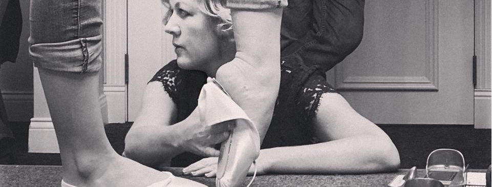 Keri Suffolk fitting a pointe shoe on a dancer's foot.