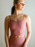 Model wearing a pink, Ribbed V front camisole cropped top with princess seams and low back.