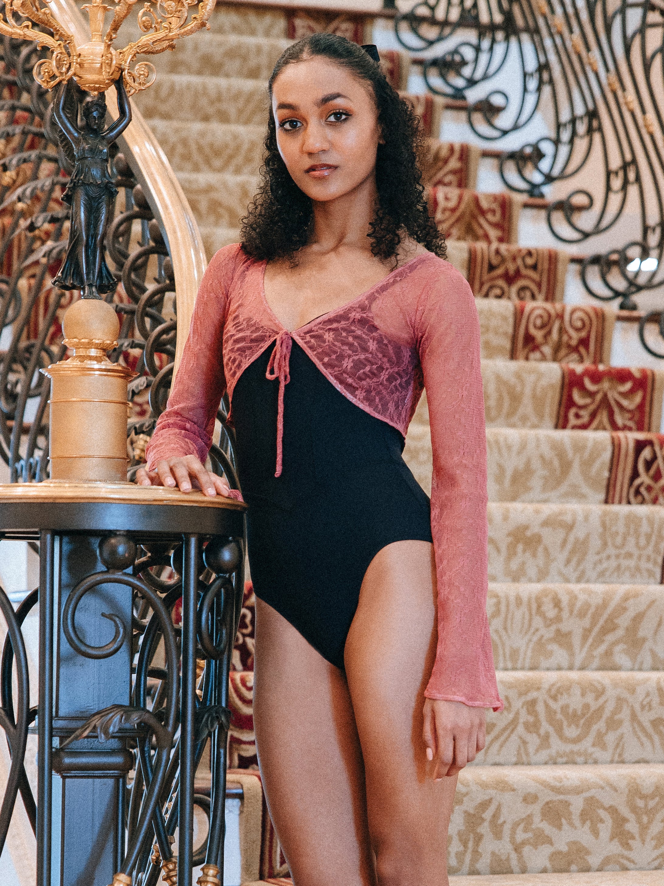 Model wearing pink, Lace tie-front cropped top with long bell sleeves.